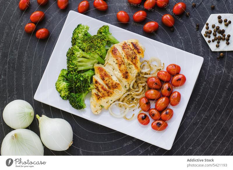 Hähnchen und Brokkoli mit Zwiebeln und Tomaten Speise Teller Gemüse dienen Paprika Tisch Kirsche gebraten lecker Lebensmittel Küche Gewürz Braten Abendessen