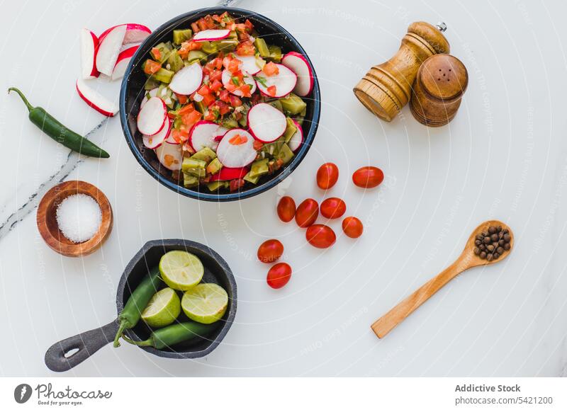 Gemischter Salat mit Radieschen um Zutaten auf weißem Hintergrund Salatbeilage Gemüse mischen Rettich Jalapeno Küche Vegetarier Gewürz Tomate Kirsche Würzig