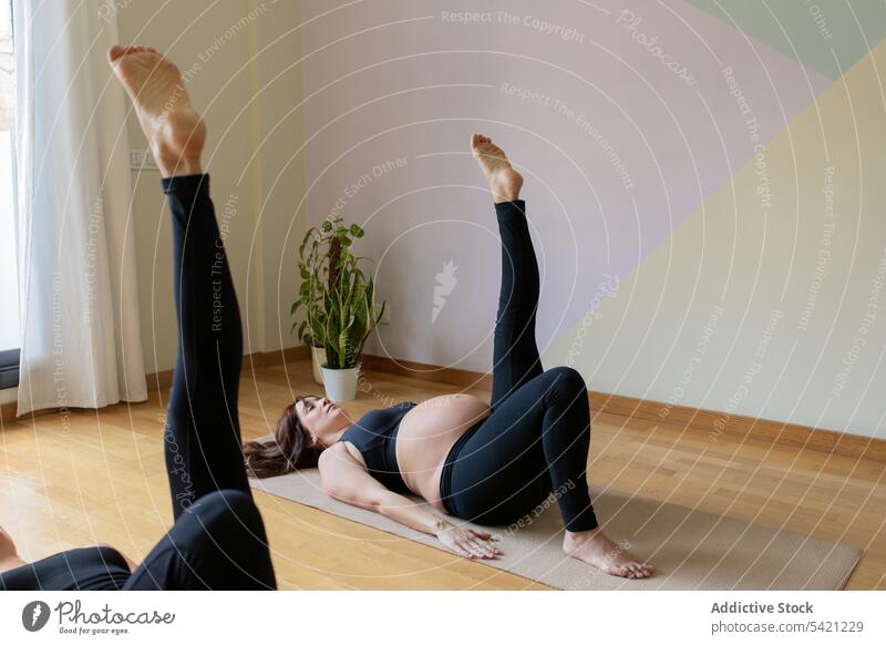 Schwangere Frau beim Yoga mit Gertencoach Frauen Atelier Trainerin schwanger Wiederholen Sie angehobenes Bein Training Übung Zusammensein Gesundheit Wellness