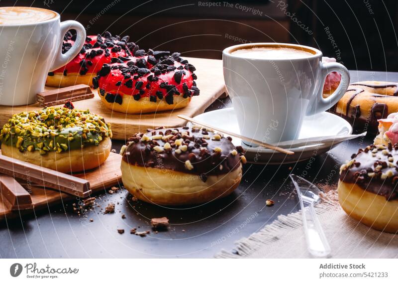 Verschiedene glasierte Krapfen und Kaffeetasse auf Schieferoberfläche Doughnut süß Schokolade Dessert Konditorei schwelgen verschiedene Kalorie Glasur