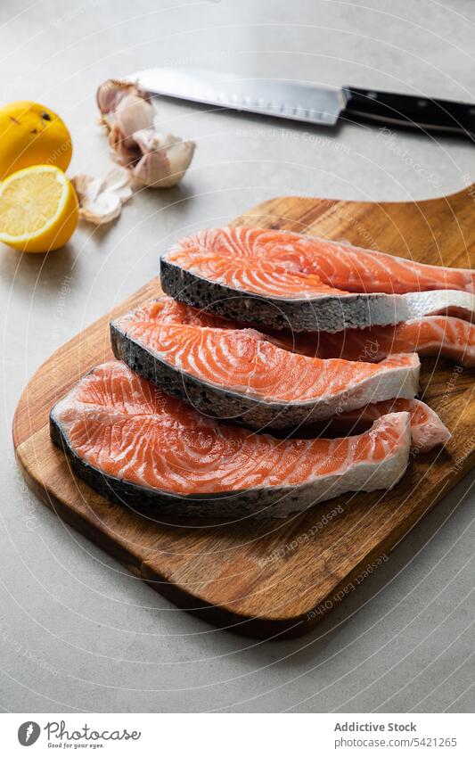 Frische Fischsteaks auf Holzbrett Lachs frisch Lebensmittel Steak roh Scheibe Schneidebrett Rezept Gesundheit Bestandteil lecker Meeresfrüchte Küche Koch rot