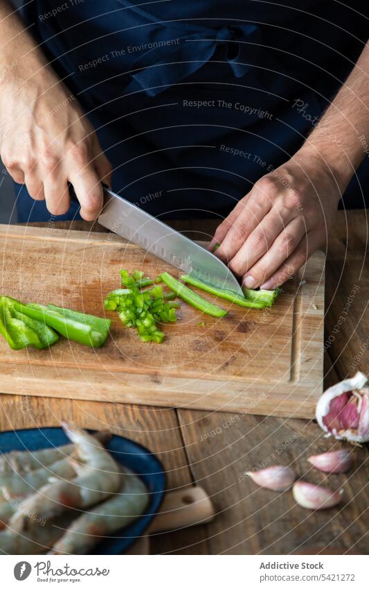 Schneiden von grünen Chilischoten beim Kochen von schmackhaften Gerichten in der Restaurantküche Küchenchef geschnitten Paprika Schneidebrett Hand Granele