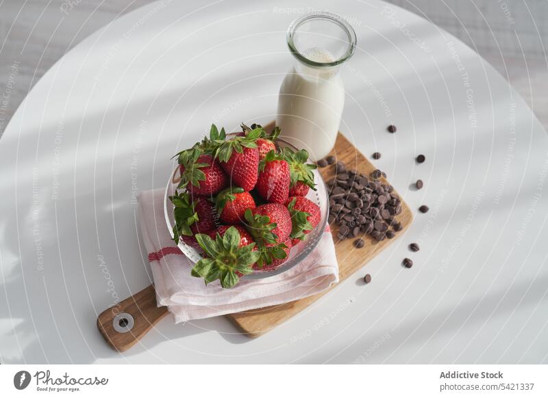 Erdbeeren und Schokoladenkugeln mit Milch melken Pellet Morgen Frühstück Tisch Küche Serviette Schneidebrett reif Haufen Flasche Schalen & Schüsseln Frucht