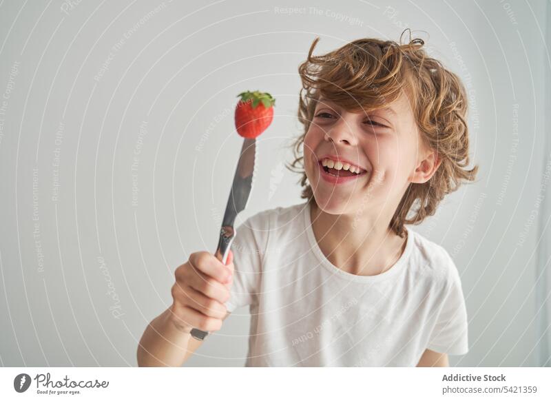 Glücklicher Junge mit Erdbeere auf Messer Erdbeeren spielen heimwärts Sommer Lächeln frisch Spaß Kind Lebensmittel Frucht Beeren Lachen reif führen süß Kindheit