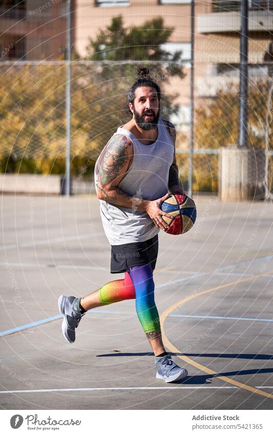 Mann mit Bart spielt Basketball auf einem städtischen Platz Gericht Konkurrenz Energie Athlet Straße Großstadt springen Training Aktion Ball Korb jung Spiel