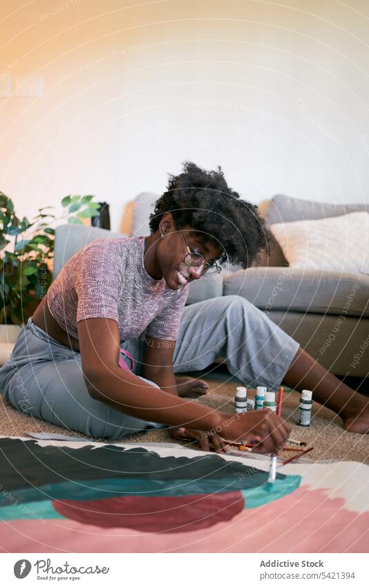 Junge afrikanische Frau malt zu Hause ein Bild Farbe Bürste heimwärts jung lässig zeichnen Fokus Amateur Hobby schwarz Freizeit Künstler ethnisch Raum