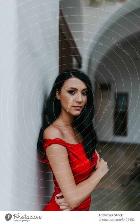 Junge Frau in rotem Kleid in der Nähe eines weißen Gebäudes Stil Wand die Arme verschränkt elegant attraktiv jung Model schlank schön hübsch trendy traumhaft