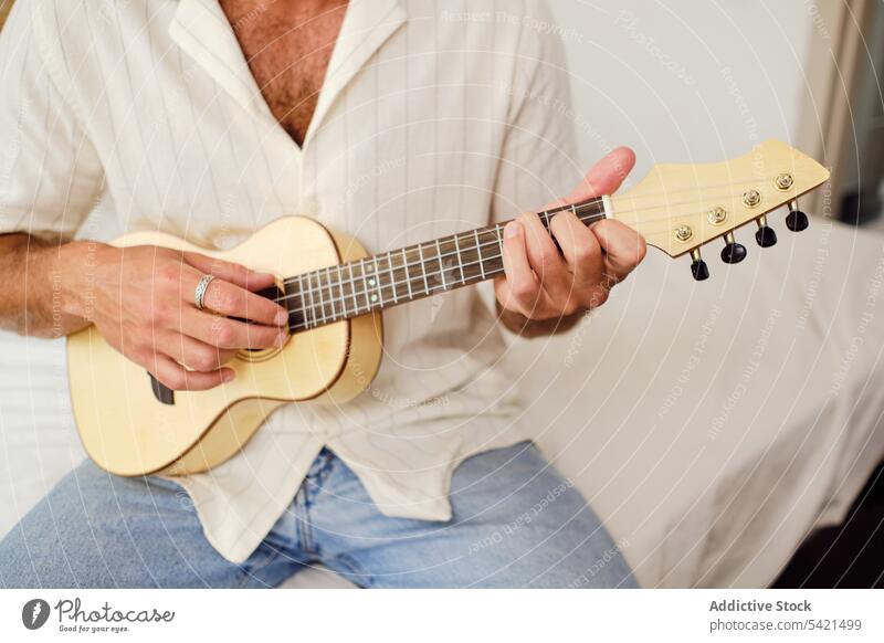 Anonymer ruhiger Mann spielt Ukulele auf weißem Hintergrund spielen Musik Musiker Gesang Gelassenheit gutaussehend Spieler männlich Instrument