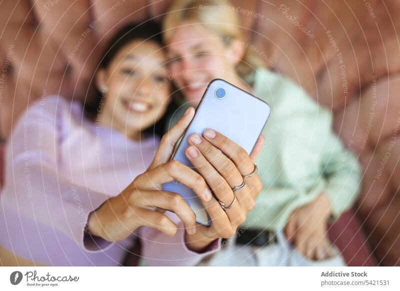 Zufriedene Teenager-Schwestern machen ein Selfie mit ihrem Smartphone auf der Couch Selbstportrait Mädchen Mobile Telefon Angebot jung Sofa benutzend Lügen