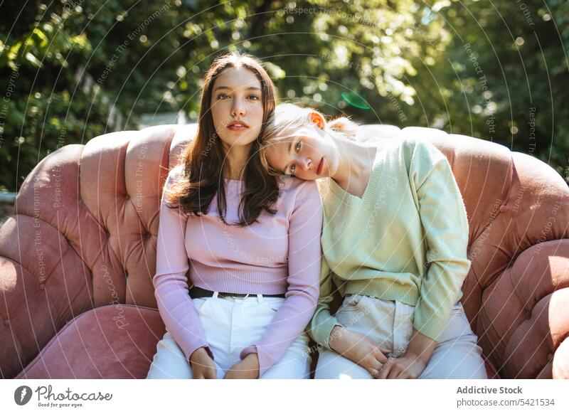 Zarte Schwestern im Teenageralter sitzen auf dem Sofa im Garten Angebot Geschwisterkind Bonden charmant Gelassenheit sich[Akk] entspannen ruhen Zusammensein