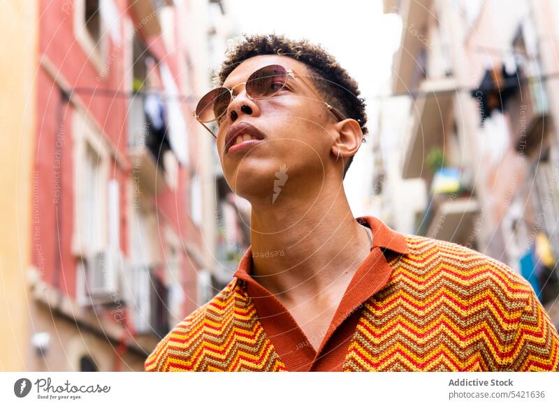 Stilvoller ethnischer Mann auf der Straße in der Stadt Reisender urban selbstbewusst zuhören trendy erkunden männlich jung hispanisch Tourist Urlaub Lifestyle