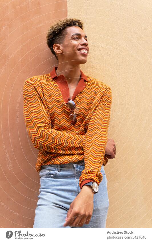 Ethnischer Mann auf der Straße stehend Stil Farbe urban orange benutzend modern jung männlich ethnisch trendy Lifestyle Hipster Scheinwerfer farbenfroh