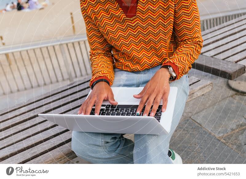 Anonymer junger Mann mit Laptop am Strand benutzend Glück Schüler freiberuflich Stil MEER Tippen positiv ethnisch trendy Lächeln Afro-Look krause Haare männlich