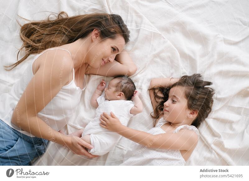 Mutter mit Tochter und Neugeborenem auf dem Bett liegend Kinder neugeboren Zusammensein Angebot Säugling Baby Eltern niedlich Glück Lügen Liebe wenig