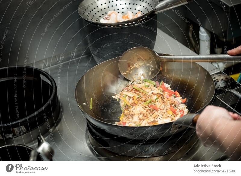 Crop Koch Kochen Garnelen gebratenen Reis im Wok in der Küche Granele Krabbe Gemüse Küchenchef Asiatische Küche Lebensmittel kulinarisch Restaurant vorbereiten