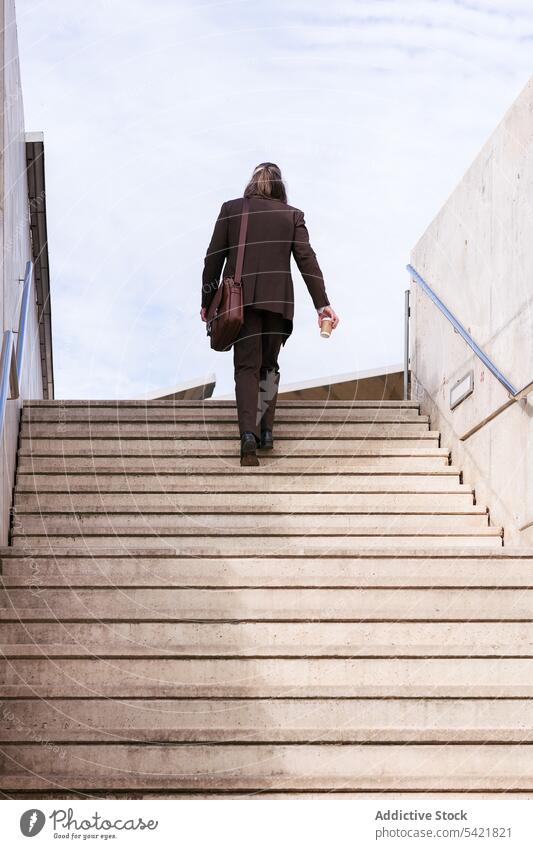 Eleganter Mann im Anzug geht eine Treppe hinauf in die Stadt Geschäftsmann Schritt Aufstieg urban stilvoll Stil Kaffee modern elegant Aktentasche Tasche