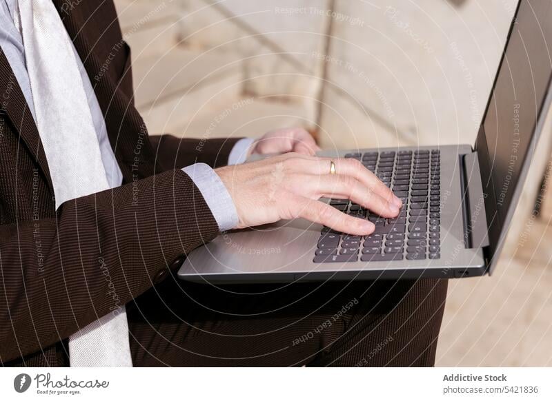 Anonymer reifer Mann im Anzug mit Laptop auf einer Treppe Geschäftsmann benutzend online abgelegen Stil Apparatur Internet Kommunizieren Unternehmer positiv
