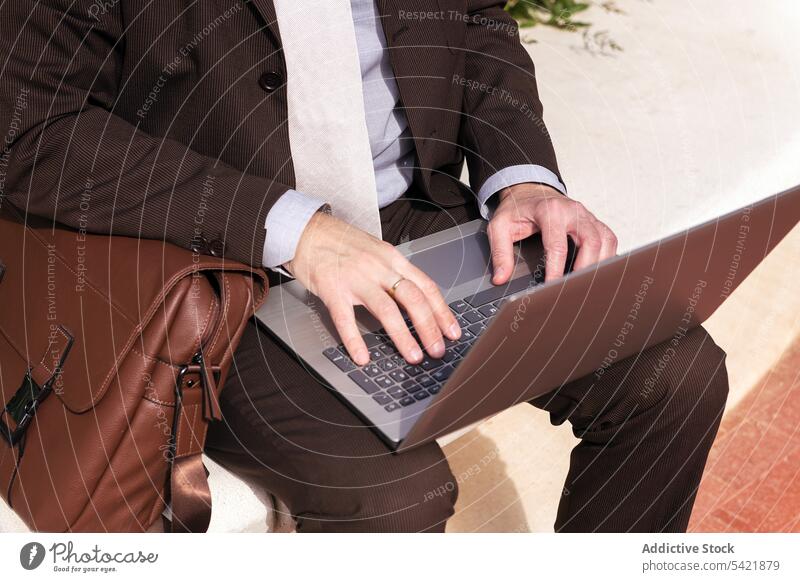 Älterer Geschäftsmann arbeitet auf der Straße an einem Laptop benutzend online abgelegen Stil urban digital Arbeit Internet Apparatur Tippen Kommunizieren Mann