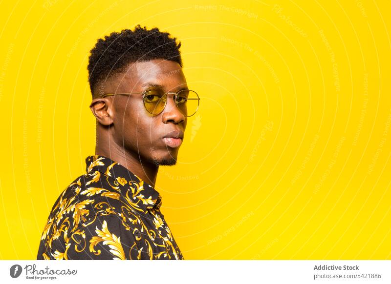 Stilvoller schwarzer Mann zeigt Shaka-Zeichen im Studio trendy Atelier Mode Porträt männlich ethnisch Afroamerikaner selbstbewusst Glück Outfit Vorschein Typ
