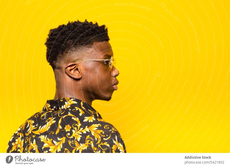 Stilvoller schwarzer Mann zeigt Shaka-Zeichen im Studio trendy Atelier Mode Porträt männlich ethnisch Afroamerikaner selbstbewusst Glück Outfit Vorschein Typ