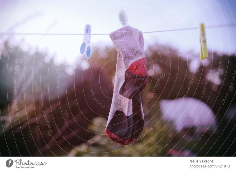 Ein Paar Socken trocknet auf einer Wäscheleine im Garten. Kniestrümpfe frisch Textil schwarz Baumwolle Mode hängende Kleidung Silhouette Hängesocken