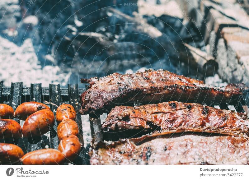 Lammkoteletts im Grill mit Chourizo gebraten Barbecue hacken chourizo gegrillt Rippen Fleisch Tier Flamme Rauch Holzkohle Kohle Lebensmittel grillen