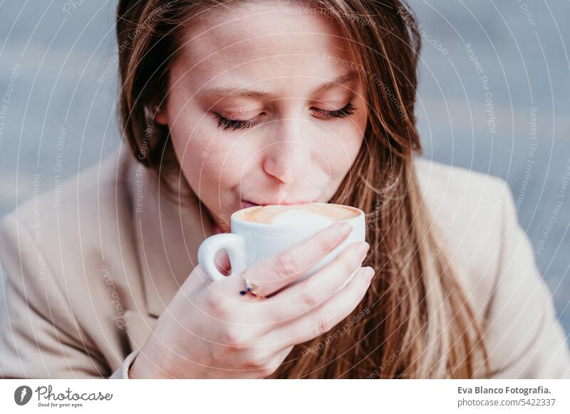 Porträt einer schönen kaukasischen Frau auf einer Terrasse beim Kaffeetrinken. Stadt- und Lifestylekonzept abschließen Café Smoothie Croissant Frühstück