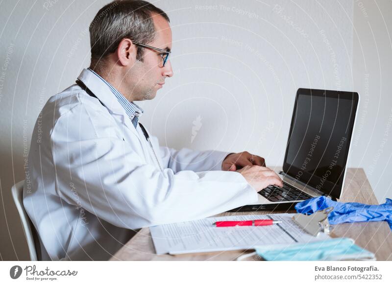 Arzt Mann arbeitet am Laptop. Corona-Virus-Test auf dem Tisch. Covid-19 Konzept Prüfung covid-19 Schutzhandschuhe Schutzmaske Technik & Technologie Analyse
