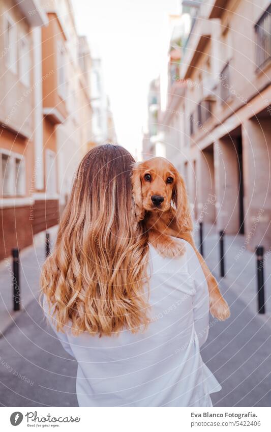 Junge Frau auf der Straße mit ihrem süßen Cocker-Hund auf der Schulter. Lifestyle im Freien mit Haustieren laufen Großstadt urban Reinrassig Kaukasier