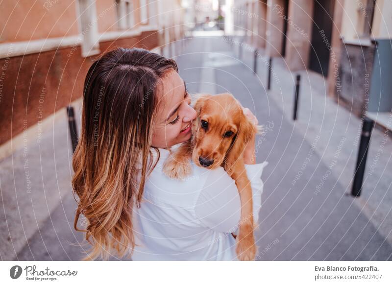 Junge Frau auf der Straße mit ihrem süßen Cocker-Hund auf der Schulter. Lifestyle im Freien mit Haustieren laufen Großstadt urban Reinrassig Kaukasier