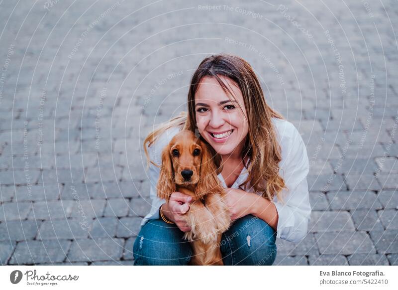 Junge Frau auf der Straße, die ihren süßen Cocker-Hund umarmt. Lifestyle im Freien mit Haustieren Freundschaft Großstadt schön laufen Lächeln Tier außerhalb