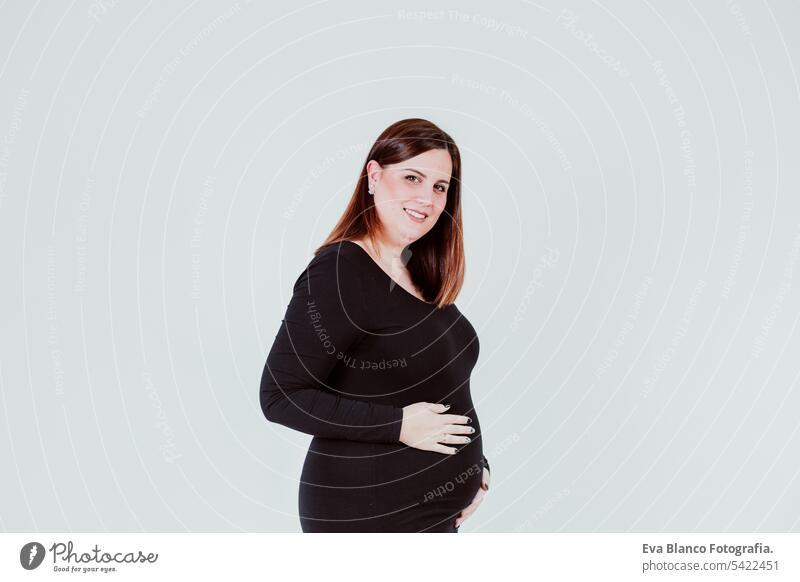 junge schwangere frau in der 21. woche zu hause, die ihren bauch berührt und lächelt. familienkonzept Frau Mutterschaft Elternschaft Baby erwartend