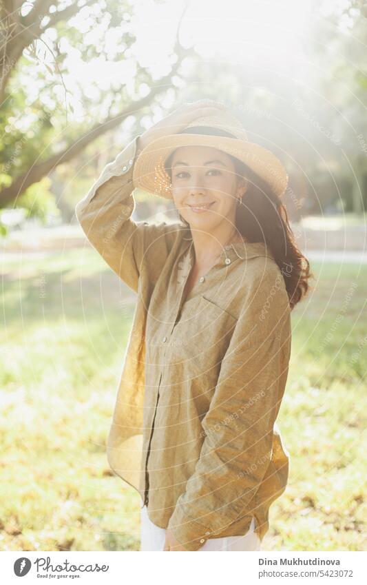 schöne 30-jährige Millennial-Frau mit Hut und olivgrünem Leinenhemd im Park mit weichem Sonnenlicht Herbst oder Sommer Porträt Junge Frau Mensch Gesicht feminin