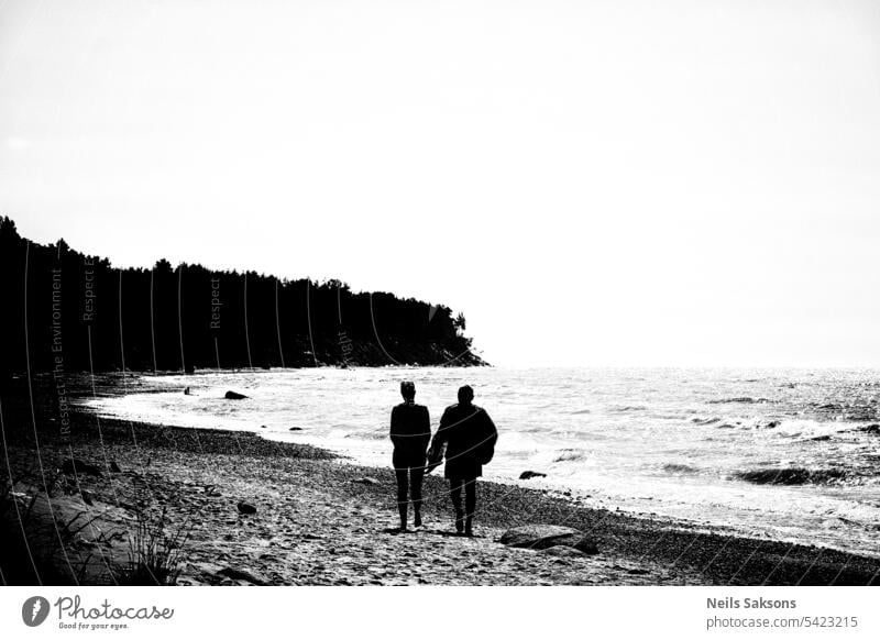 Silhouette eines Paares am Strand bei Sonnenuntergang. Schwarz-Weiß-Foto. Mann Frau schwarz auf weiß dunkel Freiheit altehrwürdig Schwarz-Weiß-Fotografie