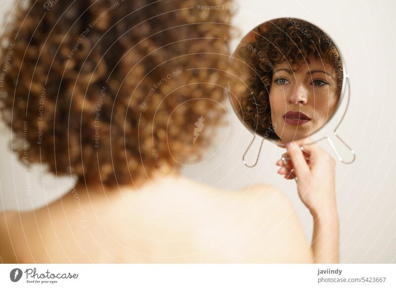 Charmante Frau mit Make-up suchen Reflexion im Spiegel Reflexion & Spiegelung krause Haare Vorschein Model selbstbewusst Schönheit Stil feminin jung trendy