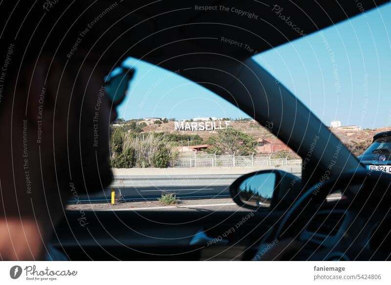 Ankunft in Marseille mit Blick aus dem Autofenster zum Schriftzug der Stadt Südfrankreich Provence Planète Mars Marseille Sign Roadtrip Mann Brille Sonnenbrille