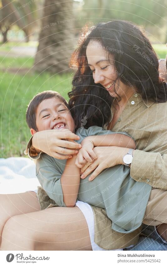 Mutter und Sohn lachend im grünen Park im Sommer im Urlaub. Glückliche Familie. Muttertag. Mutterschaft Konzept. Junge Kind Kindheit Mutter und Kind Natur