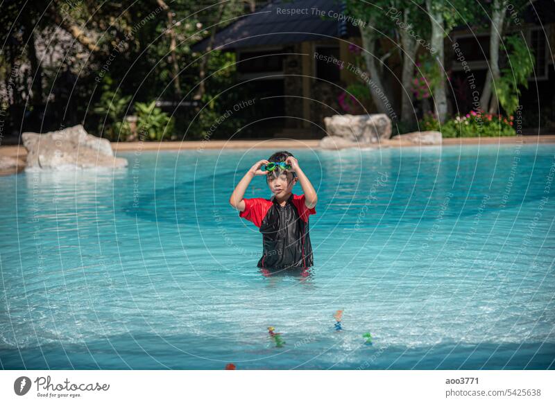 Asiatisches kleines Mädchen im Badeanzug spielt mit Spielzeug im Schwimmbad und hat Spaß. jung asiatisch Spielzeit Erholung Freizeit Sommer Wasser Geplätscher