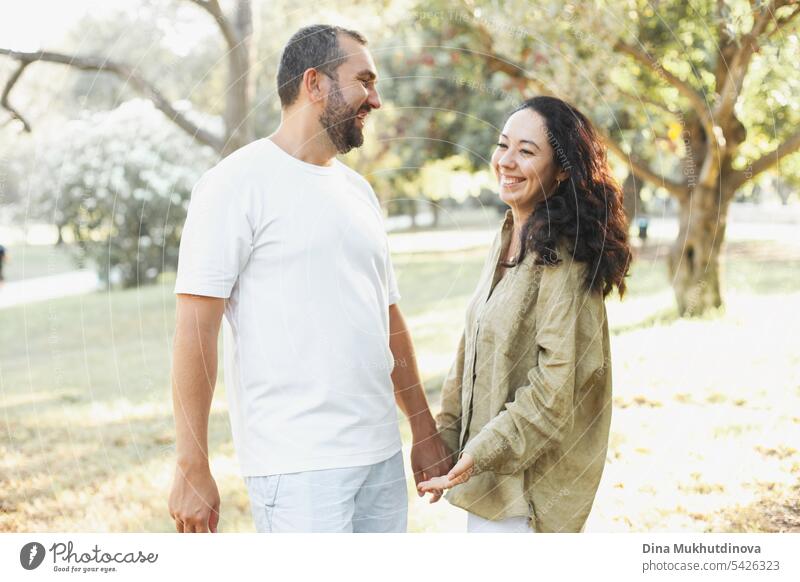 Paar lächelnd im Sommer Park in Olivenhain in grün olive Farbpalette. Erdige Töne Liebe und Paar Ziele ästhetisch. Umarmung Familie Zusammensein Leinen Ästhetik