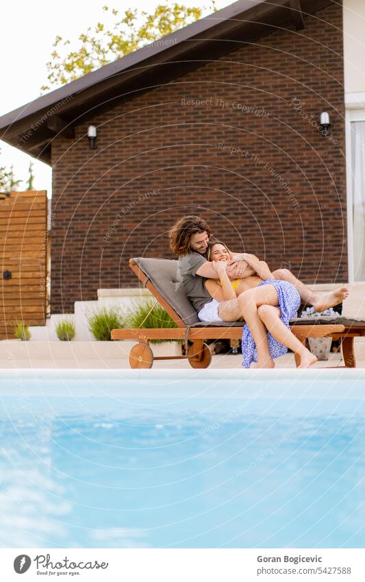 Junges Paar entspannt sich am Swimmingpool im Hinterhof des Hauses Erwachsener attraktiv Hintergrund schön Bikini Kaukasier heiter gemütlich niedlich Frau