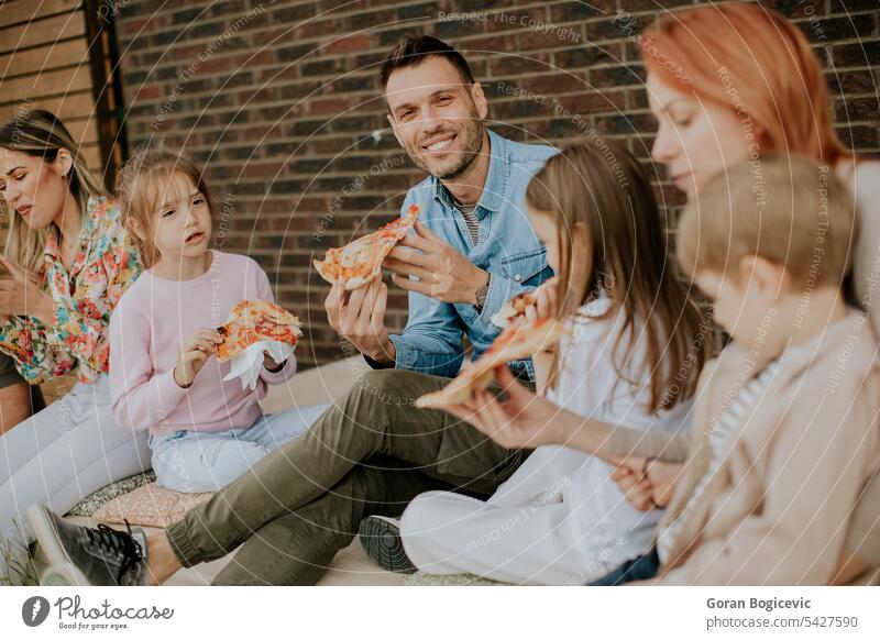 Gruppe junger Leute und Kinder essen Pizza im Hinterhof des Hauses Atmosphäre Kaukasier Paar Tochter trinken Essen genießen Familie Fastfood Vater Frau