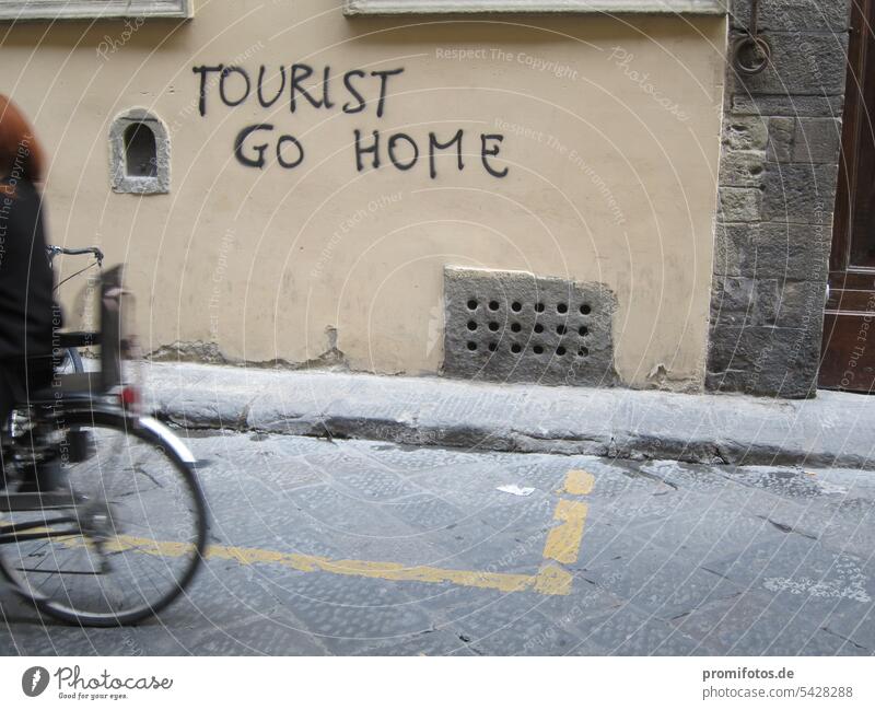 Schriftzug "Tourist go home" an einer Hauswand in Italien und Hinterrad eines Fahrrades. Foto: Alexander Hauk tourist touristin hauswand kritik protest