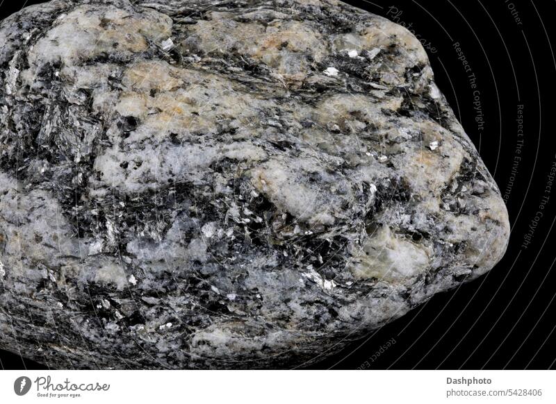 Stück Granitfelsen mit Kristallen isoliert vor einem schwarzen Hintergrund magmatisch Eruptivgestein Quarz Quarzkristalle Stein Felsen grau Nahaufnahme Objekt