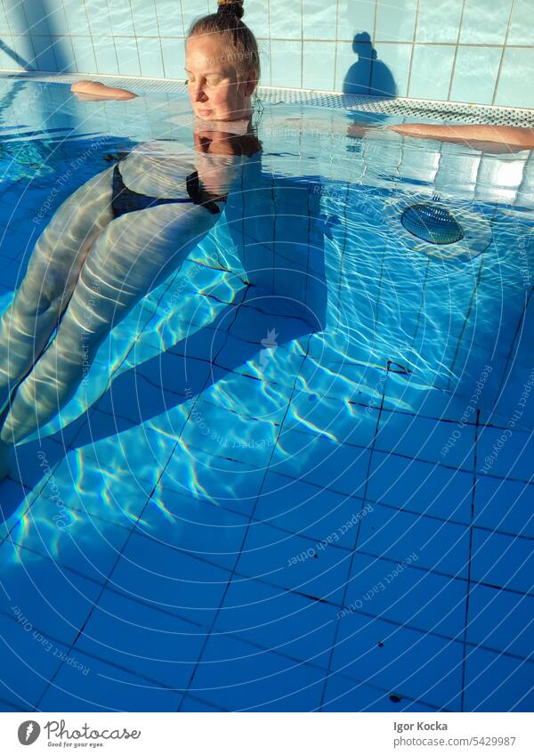 Porträt einer jungen Frau, die sich in einem Schwimmbad entspannt Erholung lustig Licht Sonnenlicht Brechung des Lichts Vergnügen Wellness Sommer Morgenlicht