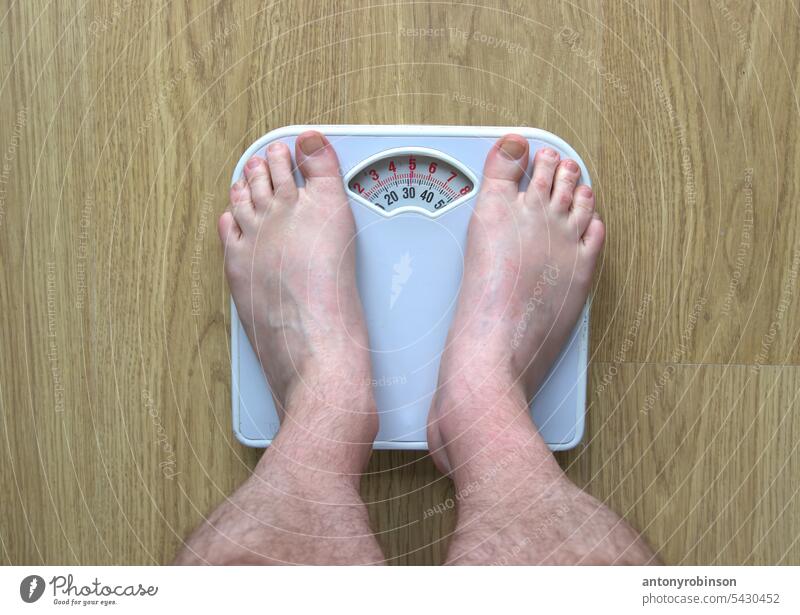 Füße eines Mannes auf einer Badezimmerwaage Fuß Körperteil männlich Erwachsener Beine Person Skala Instrument messen Messung Gewicht fettleibig Fettleibigkeit