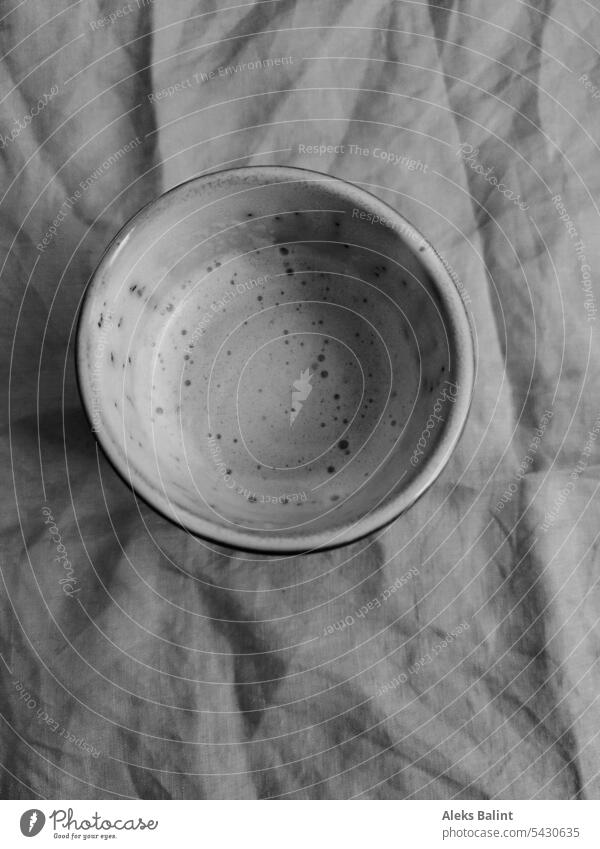 Tasse Kaffee mit Milchschaum auf einem Leinen Tischtuch in schwarzweiß Tassekaffee Kaffeetasse Kaffeepause Getränk Heißgetränk Kaffeetrinken genießen