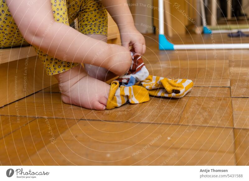 Kleinkind übt das Anziehen von Socken Socken anziehen montessori sitzen Füße dokumentarisch Alltagsfotografie Kind