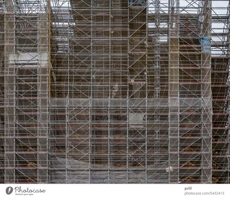 Umfangreiches Gerüst Baugerüst Inszenierung Struktur Gebäude abstützen Rohr und Kuppler Konstruktion Arbeitsbühne frontal riesig Netting Sicherheit industriell