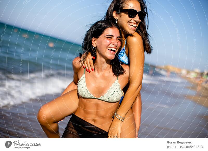 Zwei hübsche junge Frauen haben Spaß am Meer Sommer Bikini Freunde Strand Urlaub Badebekleidung MEER Zusammensein Fröhlichkeit Sand Glück Wasser heiter Genuss