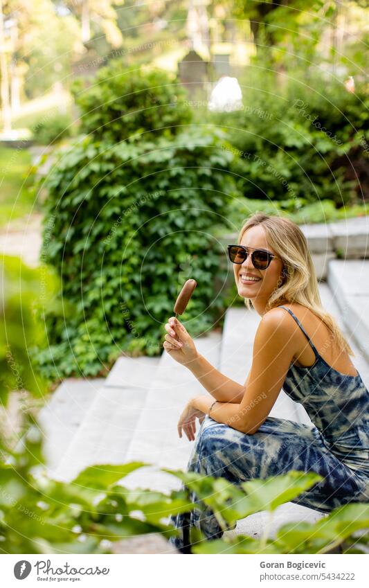 Hübsche junge Frau sitzt auf einer Treppe und isst Eiscreme weiß Kaukasier Speiseeis Sommer Glück Erwachsener Stil außerhalb Lifestyle Lebensmittel schön Spaß